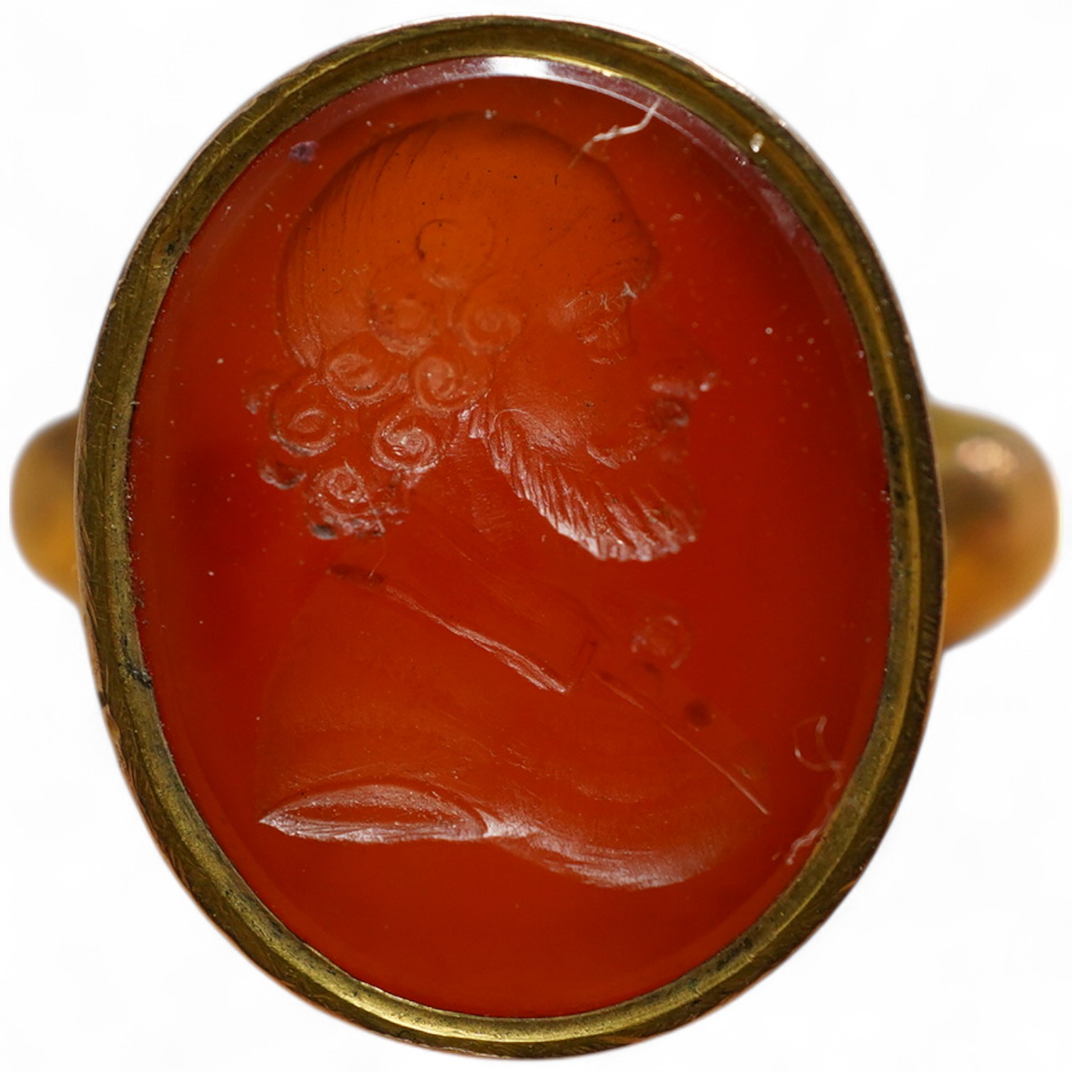 A yellow metal and intaglio carnelian set ring, the matrix carved with the bust of a gentleman to sinister, gross weigh 5.2 grams.